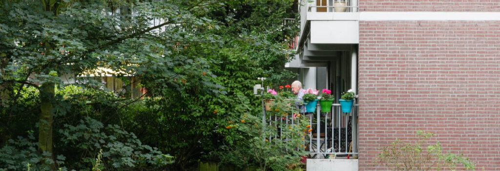 bewoner seniorenhuisvesting op balkon Wijndaeler